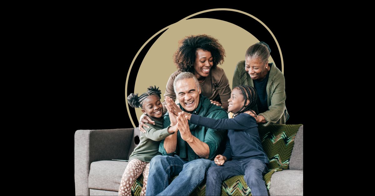 Multigenerational family members sitting on a couch smiling and laughing